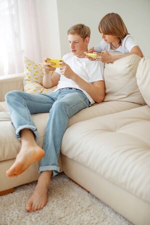 Children teenagers play a game on the phone at home.の写真素材