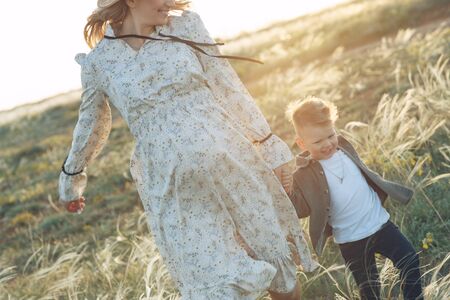 Mom with a child have fun playing in nature. A pregnant woman and a child are resting in nature.の写真素材