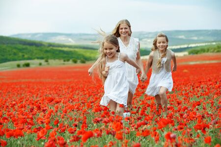 Woman with children in a field with flowers. Beautiful family on the nature.の写真素材