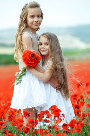 Children have fun playing in nature. Beautiful children in a field with flowers.の写真素材