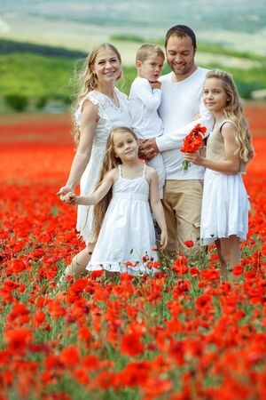 The family has fun in nature. Friendly family in a field with flowers.の写真素材