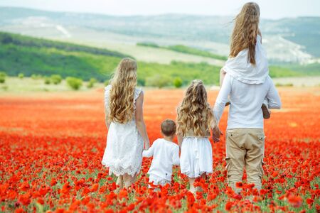 The family has fun in nature. Friendly family in a field with flowers.の写真素材