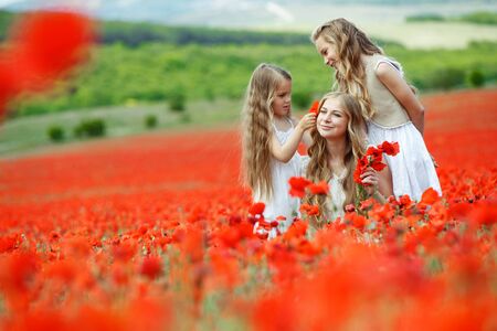 Woman with children in a field with flowers. Beautiful family on the nature.の写真素材