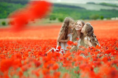 Woman with children in a field with flowers. Beautiful family on the nature.の写真素材