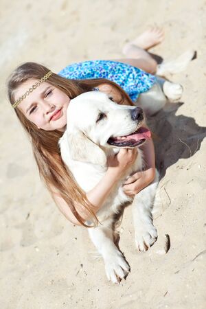 A child with a dog in nature by the sea is having fun. High quality photo.の写真素材