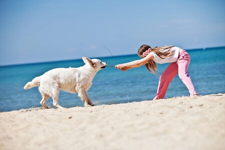 A child with a dog in nature by the sea is having fun. High quality photo.の写真素材