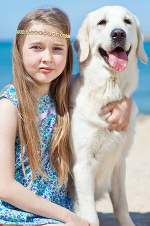 A child with a dog in nature by the sea is having fun. High quality photo.の写真素材