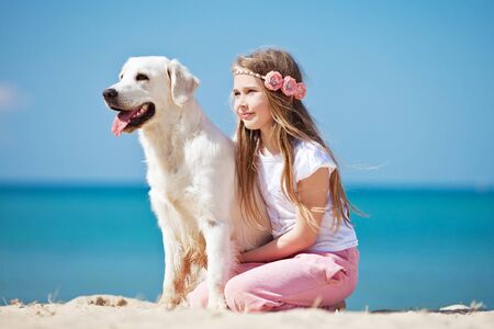 A child with a dog in nature by the sea is having fun. High quality photo.の写真素材