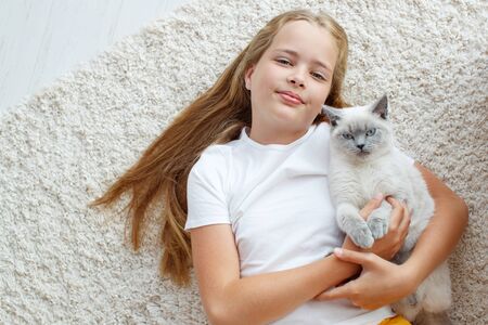A child with a cat at home. Little girl with an animal.の写真素材