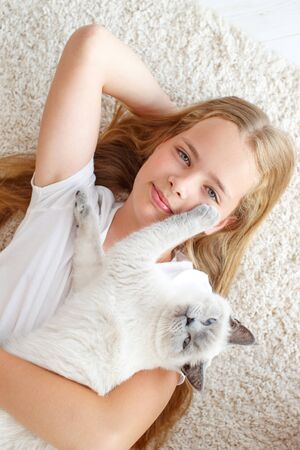 A child with a cat at home. Little girl with an animal.の写真素材