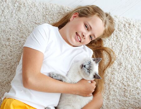 A child with a cat at home. Little girl with an animal.の写真素材