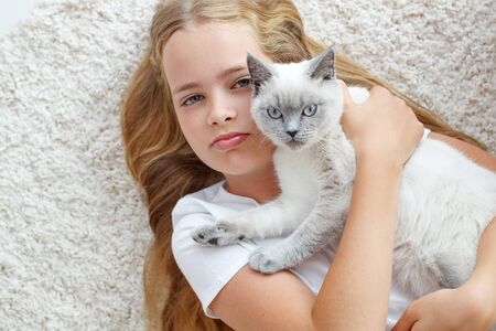 A child with a cat at home. Little girl with an animal.の写真素材
