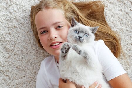 A child with a cat at home. Little girl with an animal.の写真素材