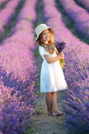 A child in lavender. Beautiful girl in a field with lavender.の写真素材