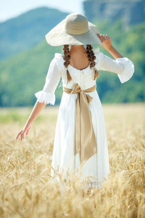 Beautiful girl in wheat in a dress. High quality photo.の写真素材