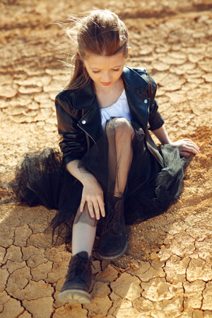 Childrens fashion. Fashionable child. Girl outdoors in fashionable clothes. High quality photo.