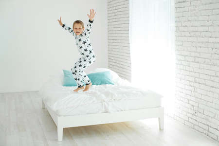 Child on the bed in pajamas. High quality photo.の写真素材
