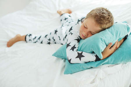 Child on the bed in pajamas. High quality photo.の写真素材