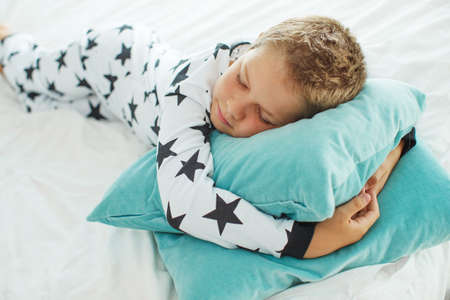 Child on the bed in pajamas. High quality photo.の写真素材