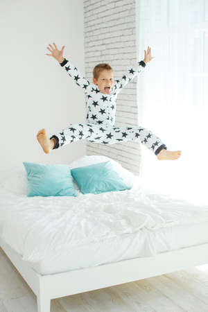 Child on the bed in pajamas. High quality photo.の写真素材