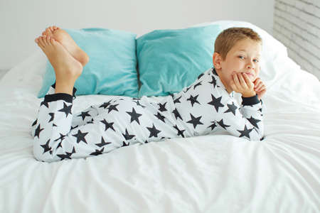 Child on the bed in pajamas. High quality photo.の写真素材