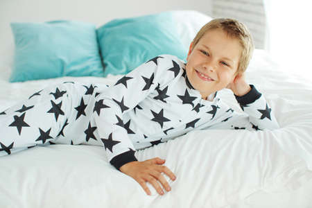 Child on the bed in pajamas. High quality photo.の写真素材