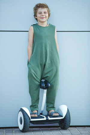 The child goes in for sports. A little boy is riding a hoverboard. High quality photo.