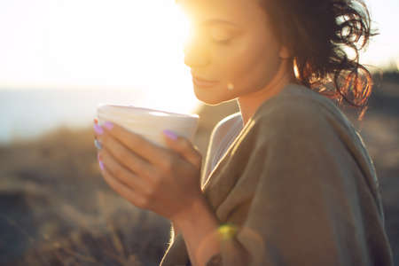 Beautiful woman drinks coffee. Woman outdoors. High quality photo.の写真素材