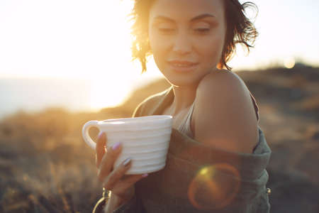 Beautiful woman drinks coffee. Woman outdoors. High quality photo.の写真素材