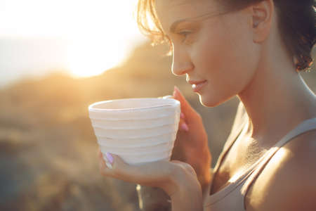 Beautiful woman drinks coffee. Woman outdoors. High quality photo.の写真素材