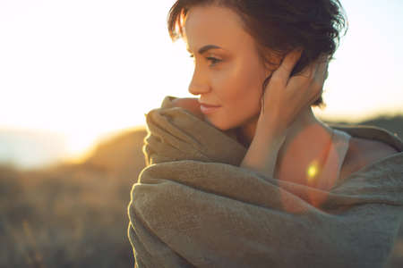 Beautiful woman. Portrait of a young woman in nature with sunset light. High quality photo.の写真素材