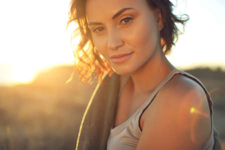 Beautiful woman. Portrait of a young woman in nature with sunset light. High quality photo.の写真素材