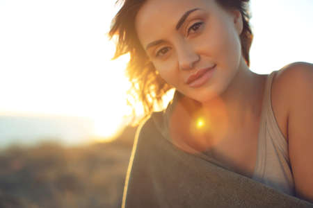 Beautiful woman. Portrait of a young woman in nature with sunset light. High quality photo.の写真素材