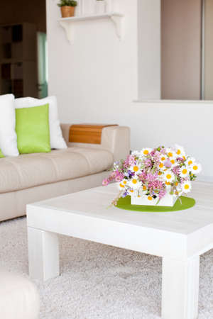 Interior with flowers, home comfort, a table with flowers and a cozy sofa next to it. High quality photo.の写真素材