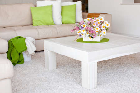 Interior with flowers, home comfort, a table with flowers and a cozy sofa next to it. High quality photo.の写真素材