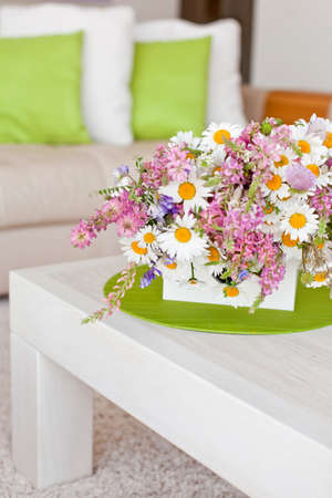 Interior with flowers, home comfort, a table with flowers and a cozy sofa next to it. High quality photo.の写真素材