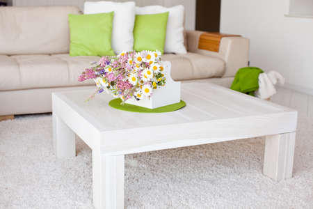 Interior with flowers, home comfort, a table with flowers and a cozy sofa next to it. High quality photo.の写真素材