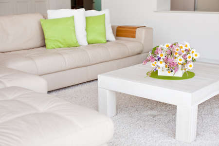 Interior with flowers, home comfort, a table with flowers and a cozy sofa next to it. High quality photo.の写真素材