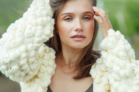 Beautiful woman wearing a sweater. Young girl in nature. High quality photo.の写真素材