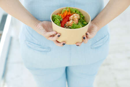 The woman is on the right diet. Fat woman eats salad. High quality photo.の写真素材