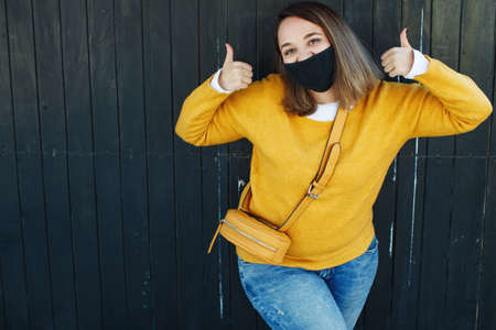 The woman in the mask. Beautiful young woman wears a mask with a pandemic. High quality photo.の写真素材