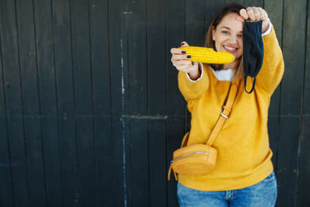 The woman in the mask. A beautiful young woman wears a mask during a pandemic. Mask and food. High quality photo.の写真素材