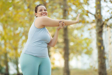 Fat woman and sports. Does exercise for weight loss in the fresh air. High quality photo.の写真素材