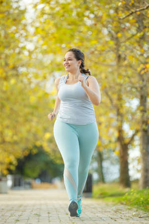 Fat woman and sports. Does exercise for weight loss in the fresh air. High quality photo.の写真素材