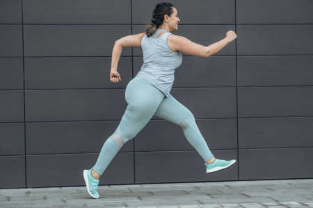 Fat woman jogging, doing sports for weight loss, obesity problem. High quality photo.の写真素材