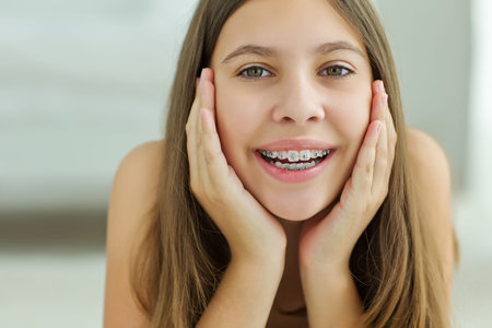 Close up portrait of smiling teenager girl showing dental braces.Isolated on white background. High...