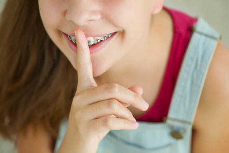 Close up portrait of smiling teenager girl showing dental braces.Isolated on white background. High...