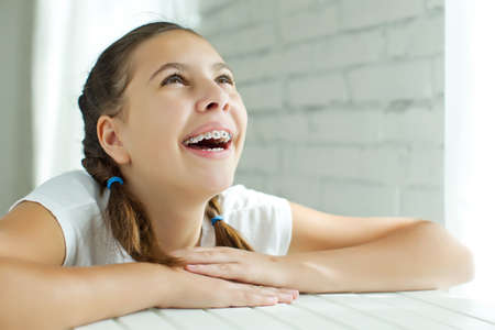 Close up portrait of smiling teenager girl showing dental braces.Isolated on white background. High quality photo.の写真素材