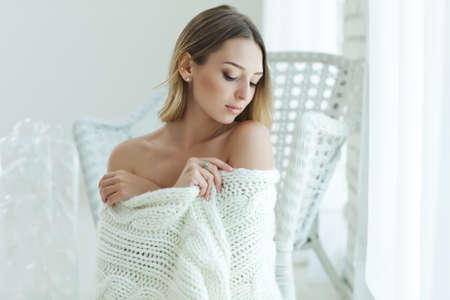 Young woman relaxing with chunky wool blanket. Relax, comfort lifestyle. Winter style. High quality photo.の写真素材