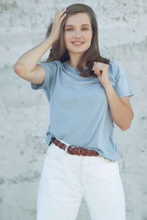 Portrait of cheerful mature woman standing against grey wall. Smiling carefree woman looking at camera. High quality photo.の写真素材